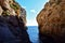 Closeup of cliffs surrounded by the sea under the sunlight in Wied Babu, Malta