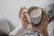 Closeup of a coffee mug with foamy latte in girls hands