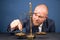 Closeup of coins on weighing scale with businessman in background