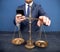 Closeup of coins on weighing scale with businessman in background