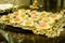 Closeup of colorful Brazilian fudge balls (truffle) lined up in the golden tray, on the glass table