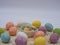 Closeup of colorful cookies in a white bowl surrounded by multicolor easter knitted eggs