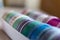 A closeup of colorful washi tape in different patterns and colors in a box. The decorative rolls are ready to use to decorate a
