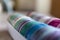 A closeup of colorful washi tape in different patterns and colors in a box. The decorative rolls are ready to use to decorate a