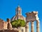 Closeup on columns of Roman Forum with church cupola in Rome, It