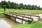 Closeup of concrete bridge and irrigation canal with tree background