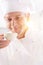 Closeup of confident mature chef smelling food in bowl at restaurant