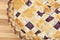 Closeup of Cooked Cherry Pie with Lattice on a Wood Cutting Board