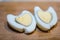 Closeup cooked herat shape eggs on the wooden cutting board for valentines