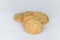 Closeup cookies are arranged in multiple pieces, stacked together, and the cookies are brown and the image has blank space beside