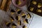 Closeup of cookies of different shapes on the plate, pan, and metallic bars with a brown napkin