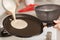 Closeup cooking pancakes on a gas stove. On a hot skillet liquid dough from the ladle is poured