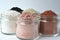 A closeup of cosmetic clays for detox face masks - French green clay, kaolin, pink clay, red clay and powdered activated charcoal