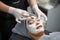 Closeup cosmetologist is applying facial white mask cream on woman client face in beauty clinic