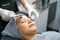Closeup cosmetologist use cosmetic brush applying facial jelly\'s gel on woman client face in beauty clinic