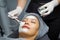 Closeup cosmetologist use cosmetic brush applying facial jelly\'s gel on woman client face in beauty clinic