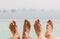 Closeup of couple feet over sea and sky on beach