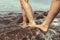 Closeup of a couple of friends enjoying their time by walking on the rocks by the wavy ocean