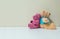 Closeup couple of pink and brown bear doll on white desk and wall textured background with copy space