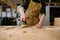 Closeup craftsman hands working with eccentric grinding machine