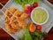Closeup crispy deep fried battered shrimp serve with vegetables and cream salad