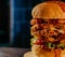 Closeup of crispy double fried chicken burger on wooden board on blur background