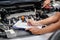 Closeup and crop auto repair post a list of repairs according to customer orders on car engine background