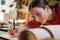 Closeup and crop young female leather goods maker is drawing a design on leather in leather workshop