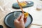 Closeup cropped shot of unrecognizable female artisan using piece of beeswax to create wick for handmade candle at home.