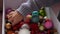 Closeup cropped shot of unrecognizable happy little girl taking out festive Christmas tree ball from box with various