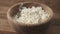 Closeup crumbly cottage cheese in wood bowl