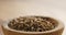 Closeup of cumin zira seeds in wood bowl on table