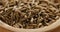 Closeup of cumin zira seeds in wood bowl on table