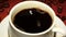 Closeup. In cup with black coffee falls one piece sugar
