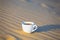 Closeup cup of cofee on a sand