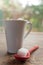 Closeup of cup of cofee, sugar cube and a red spoon