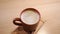 closeup of cup with hot chocolate cocoa drink or cappuccino on wooden plate