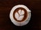Closeup cup of hot coffee tulip latte art on wood table, vintage