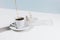 Closeup of cup with pouring coffee, saucer and creamer