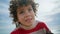 Closeup curly kid posing at cloudy sky. Adorable little boy resting outdoors