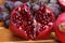 Closeup of a cut ripe juicy red Armenian pomegranate and grapes