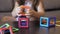 Closeup of cute 5 years old girl is sitting at the table on a sofa and playing a magnetic constructor building a house