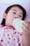 Closeup cute asian girl suck up milk bottle. Drinking milk for g