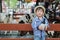 Closeup cute asian kid prepared to milking calf by bottle of milk in farm background