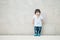 Closeup cute asian kid stand on marble stone wall textured background with copy space