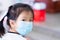 Closeup of cute kid girl wearing blue face mask. Empty space for entering text. Prevent spread of virus and toxic dust PM2.5