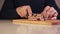 Closeup of cutting chopping a piece of bacon into smaller pieces. Closeup of male hands slicing a piece of bacon.