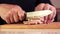 Closeup of cutting chopping a piece of bacon into smaller pieces. Closeup of male hands slicing a piece of bacon.