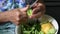 Closeup cutting cucumber peels with knife in wrinkled hands of senior woman