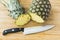 Closeup cutting a pineapple on wooden background